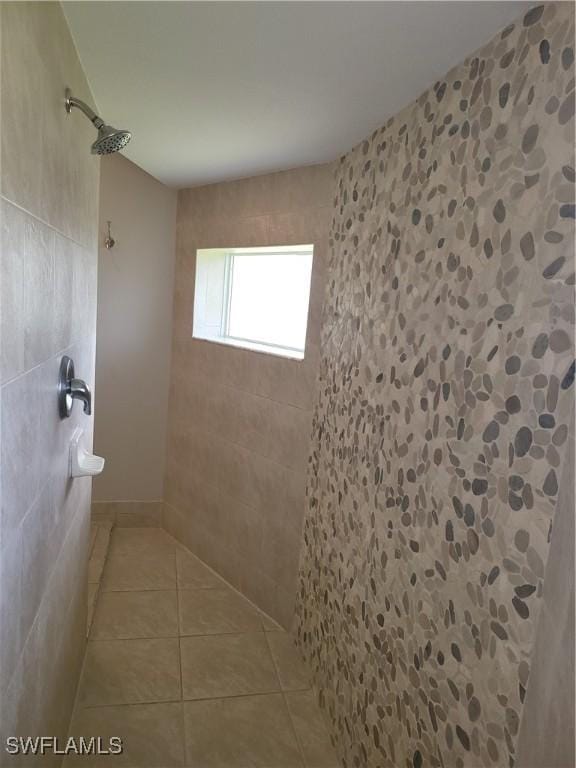 bathroom featuring tile patterned flooring and tiled shower