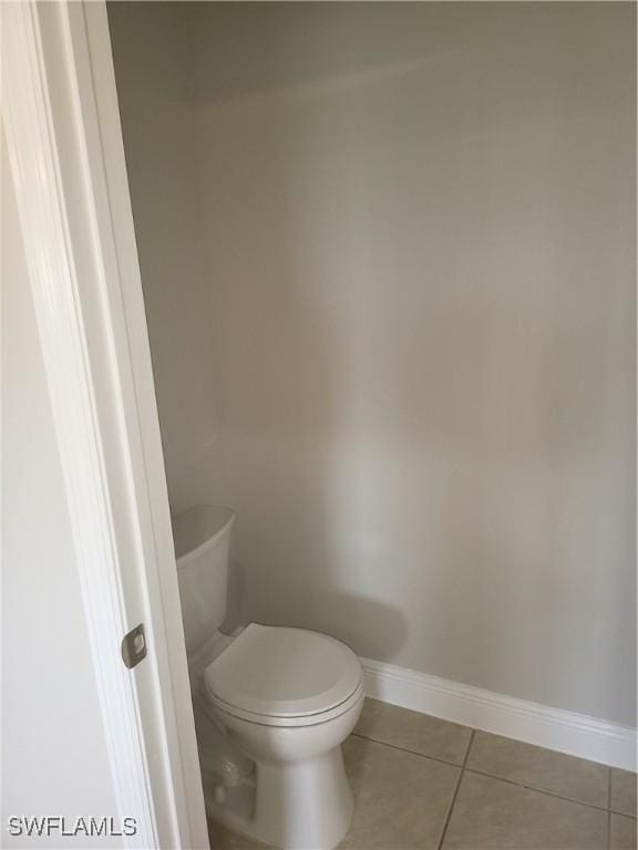 bathroom featuring baseboards, toilet, and tile patterned floors