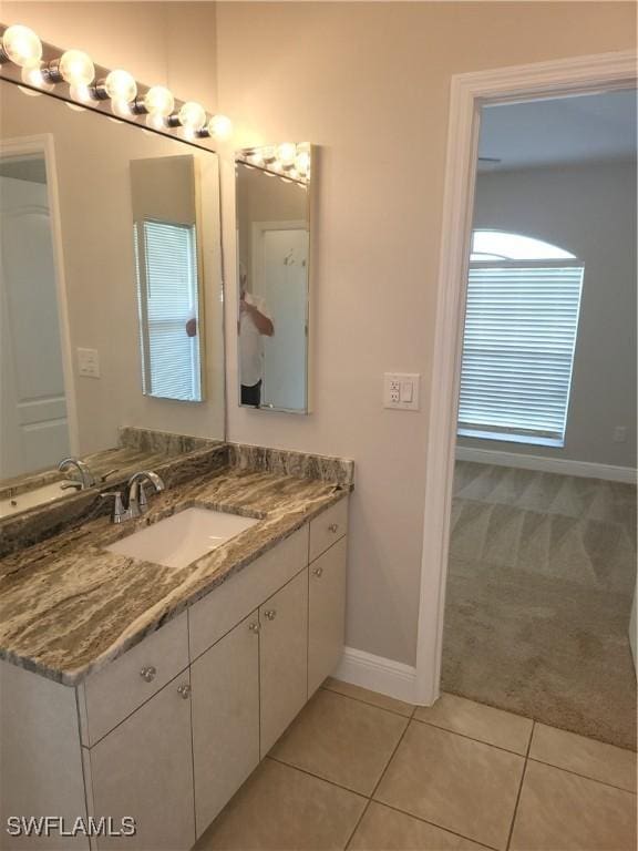 bathroom featuring tile patterned flooring, vanity, and baseboards