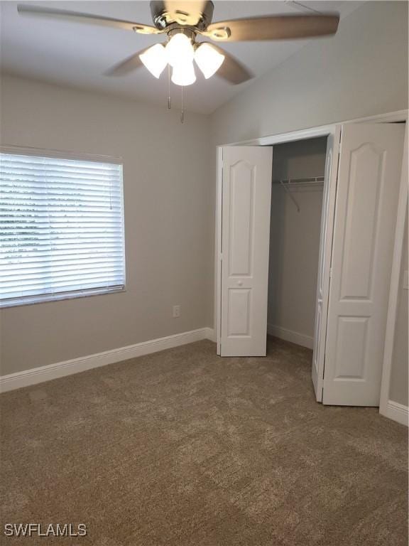 unfurnished bedroom with light carpet, baseboards, a closet, and lofted ceiling