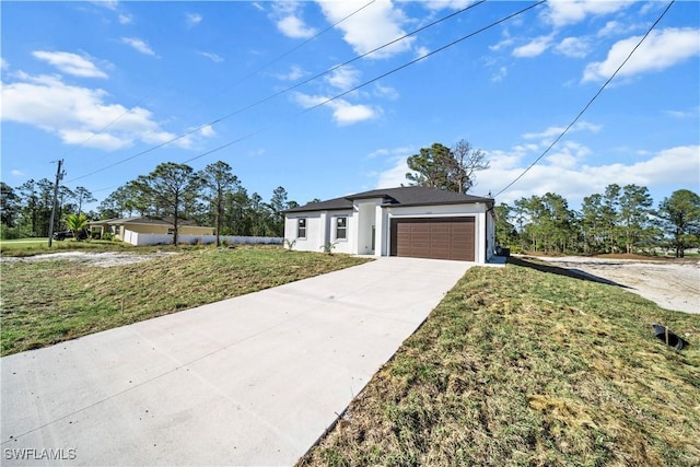 view of front of property featuring a front lawn, concrete driveway, and an attached garage