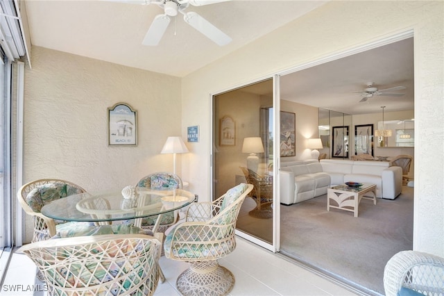 interior space with ceiling fan and a textured wall