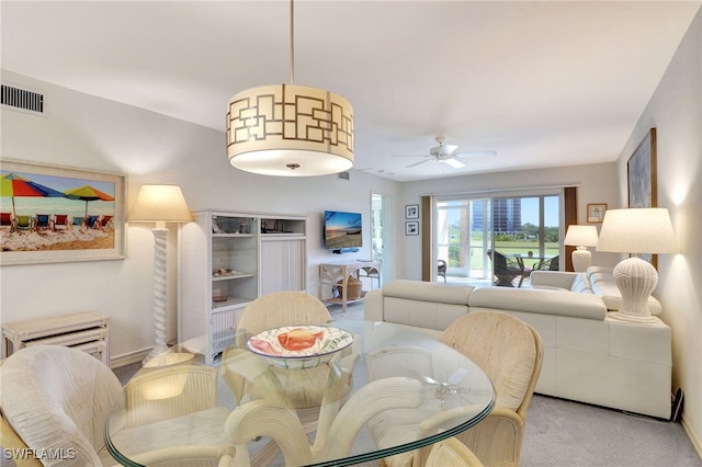 dining area featuring light colored carpet, visible vents, and ceiling fan