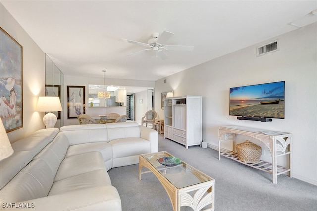 carpeted living room with ceiling fan, visible vents, and baseboards