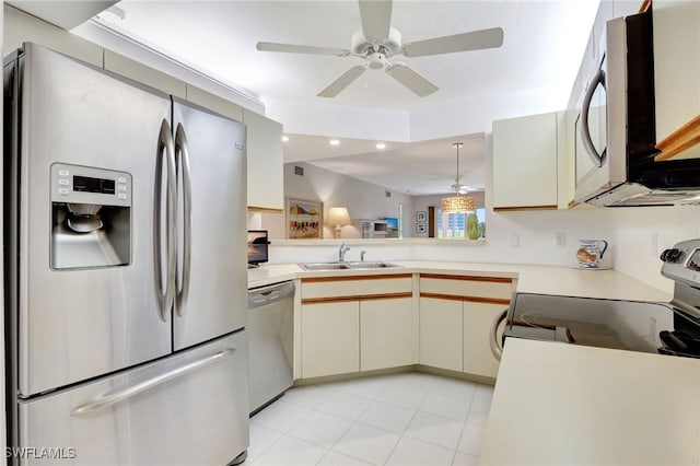 kitchen featuring recessed lighting, a sink, light countertops, appliances with stainless steel finishes, and cream cabinetry