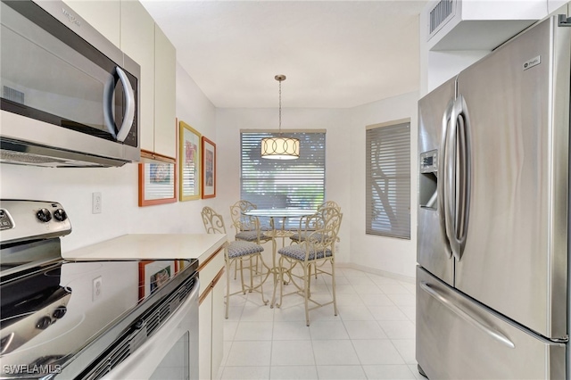 kitchen featuring light tile patterned flooring, visible vents, light countertops, appliances with stainless steel finishes, and hanging light fixtures