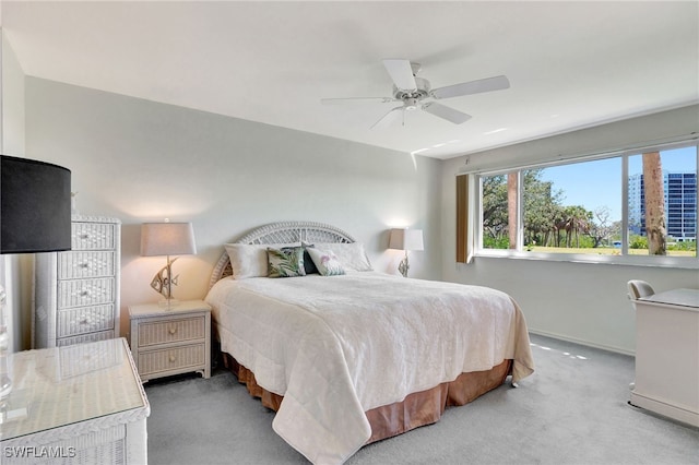 carpeted bedroom with ceiling fan and baseboards