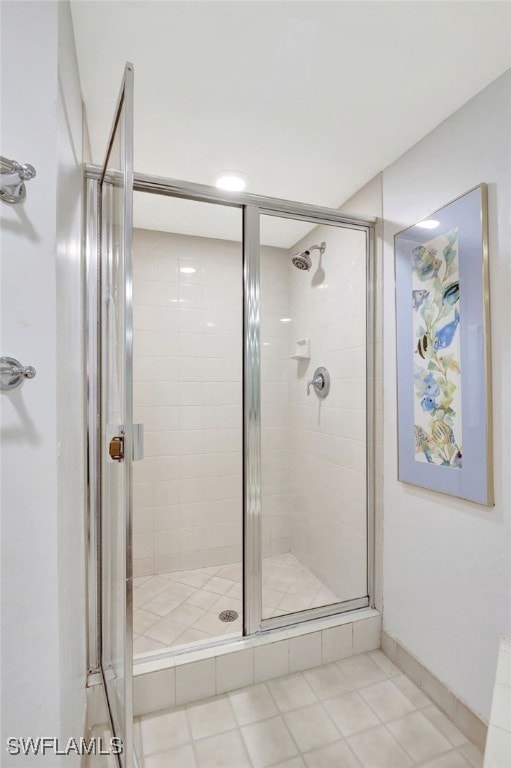 bathroom with tile patterned flooring and a shower stall