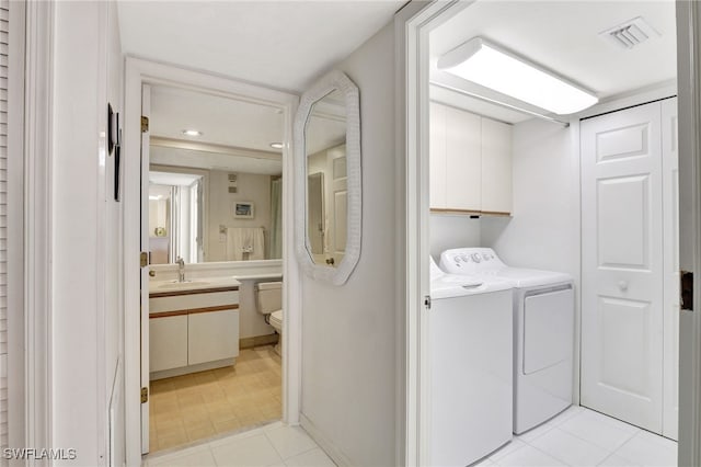 clothes washing area featuring cabinet space, visible vents, separate washer and dryer, and a sink