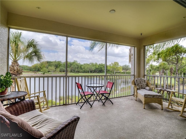 sunroom featuring a water view