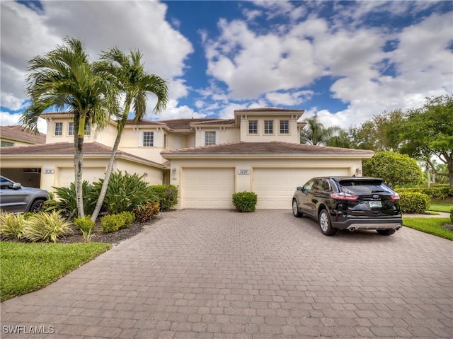 view of front facade featuring decorative driveway, a garage, and stucco siding