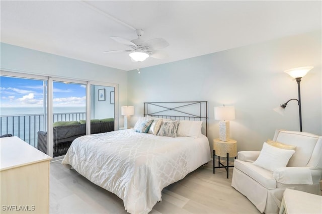 bedroom with a water view, access to exterior, ceiling fan, and light wood finished floors