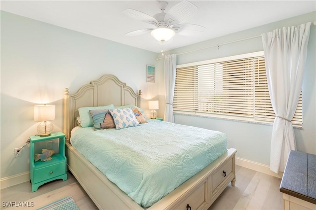 bedroom with light wood-style floors, baseboards, and a ceiling fan