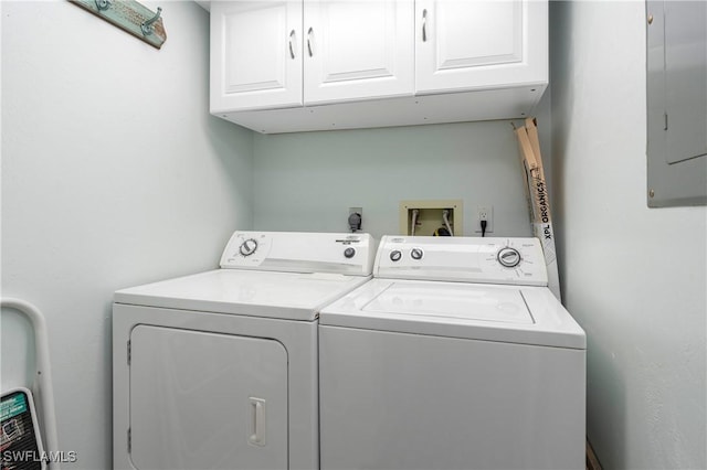 washroom with cabinet space, washing machine and dryer, and electric panel