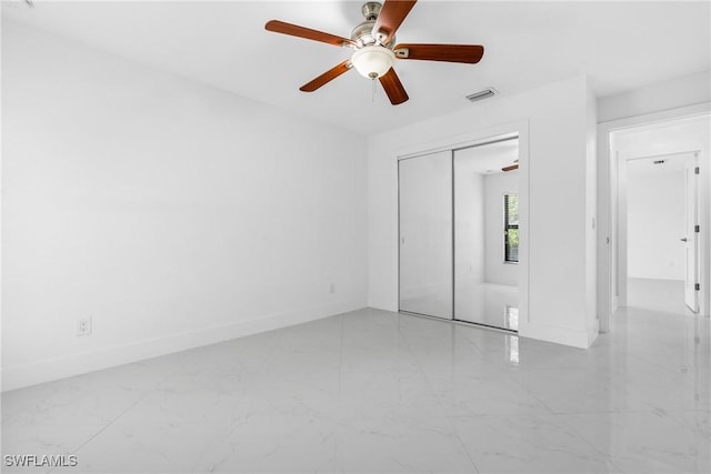 unfurnished bedroom with marble finish floor, a closet, visible vents, ceiling fan, and baseboards