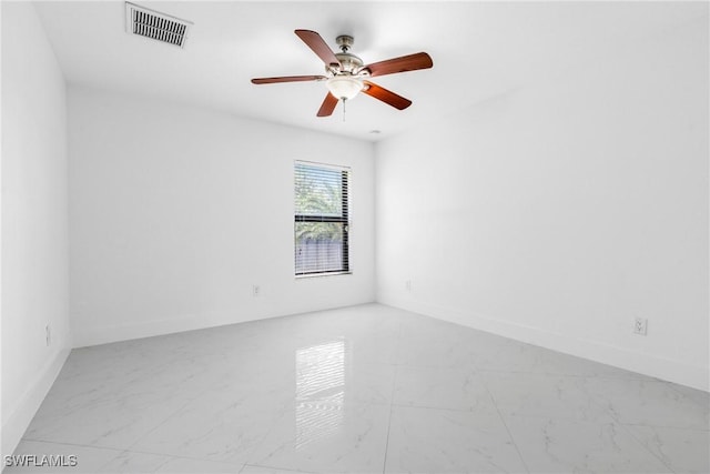 spare room featuring marble finish floor, visible vents, and baseboards