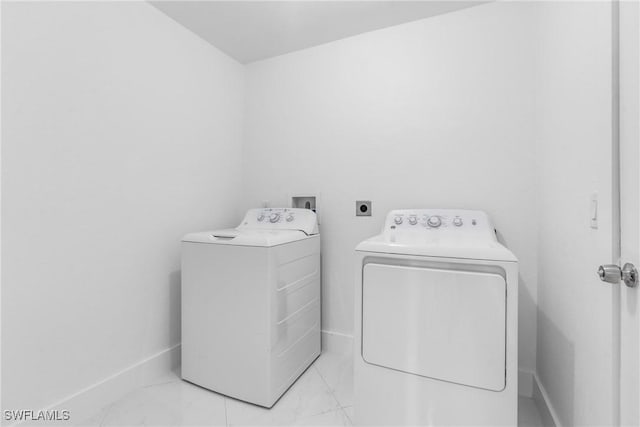 washroom featuring laundry area, baseboards, marble finish floor, and washer and dryer