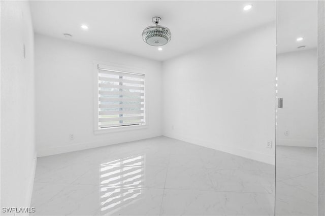 unfurnished room with recessed lighting and baseboards