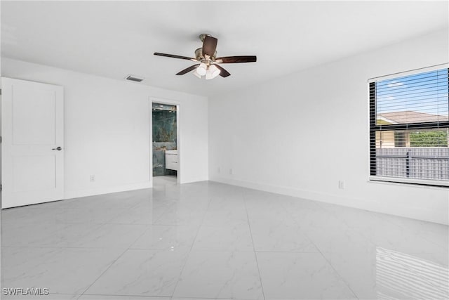 empty room with marble finish floor, baseboards, visible vents, and a ceiling fan