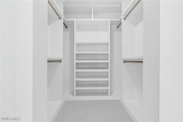 walk in closet with marble finish floor