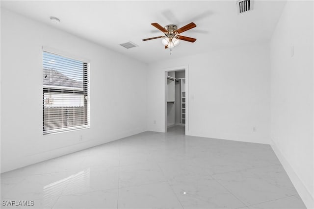 spare room featuring a ceiling fan and visible vents