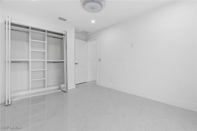 unfurnished bedroom featuring recessed lighting, visible vents, baseboards, marble finish floor, and a closet