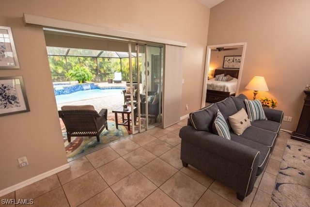 living area featuring tile patterned flooring, a sunroom, and baseboards