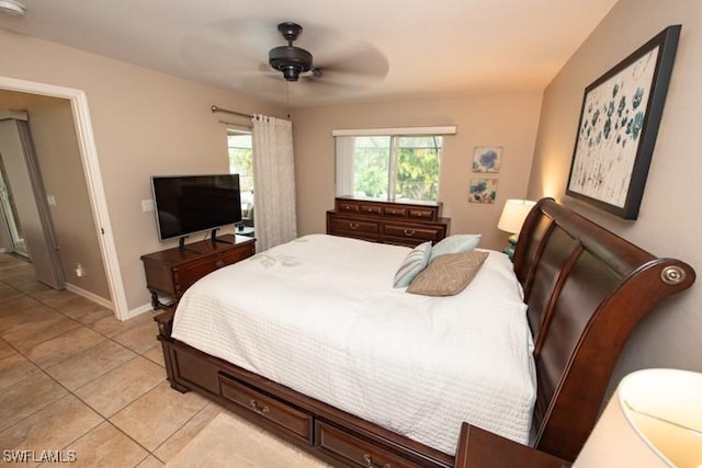 bedroom with light tile patterned floors, a ceiling fan, and baseboards