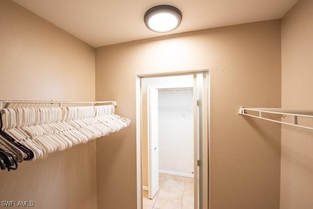 walk in closet with light tile patterned floors