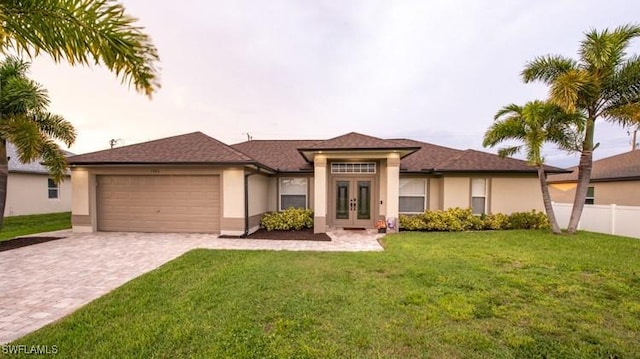 prairie-style home featuring decorative driveway, french doors, an attached garage, and stucco siding