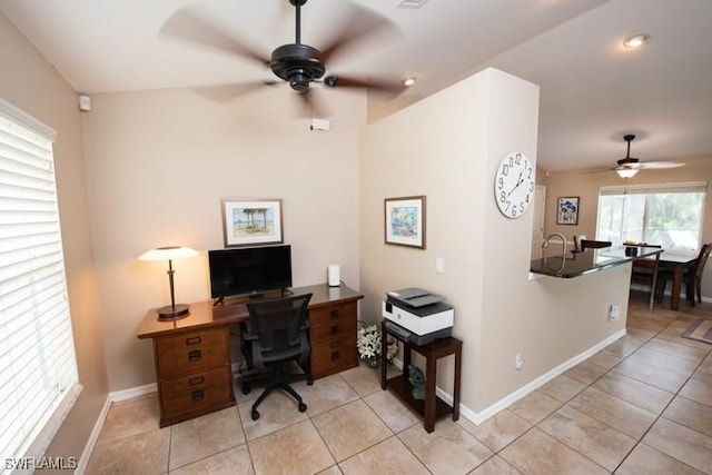 office space with baseboards, a ceiling fan, and light tile patterned flooring