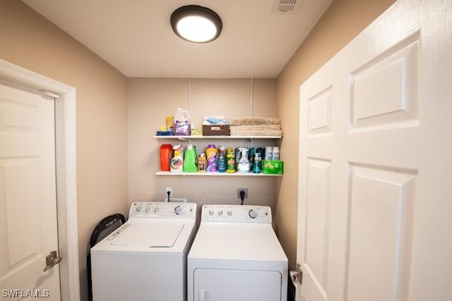 laundry area with laundry area, visible vents, and washing machine and clothes dryer