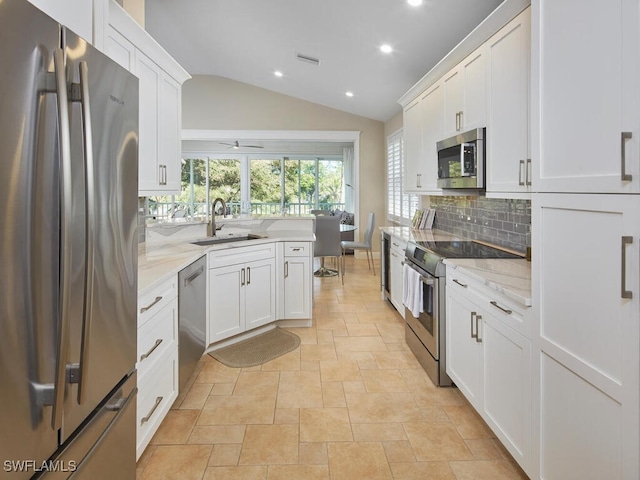 kitchen with stainless steel appliances, a sink, visible vents, white cabinets, and tasteful backsplash