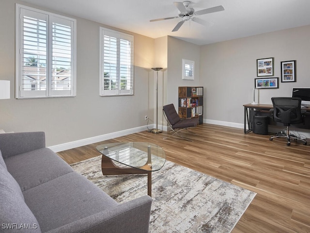 office area with wood finished floors, a ceiling fan, and baseboards