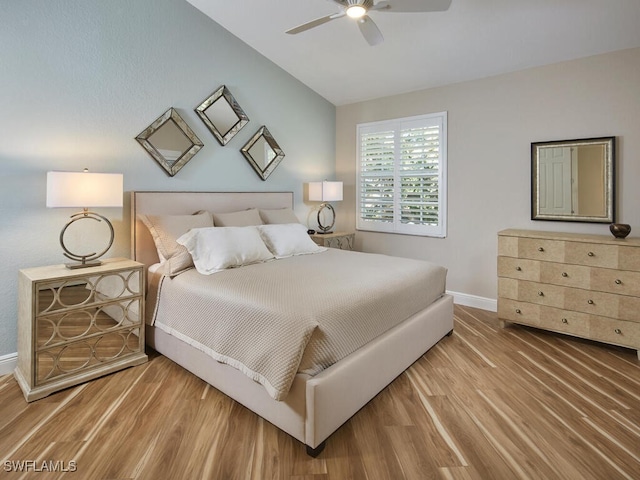 bedroom featuring vaulted ceiling, wood finished floors, a ceiling fan, and baseboards