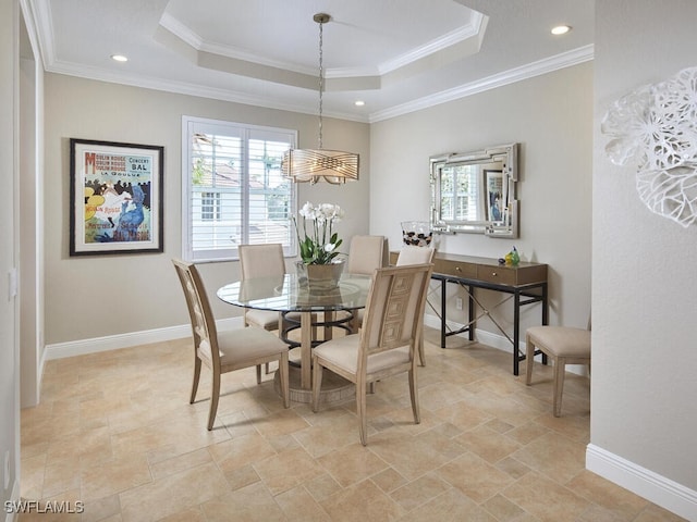 dining room featuring baseboards, a tray ceiling, and ornamental molding