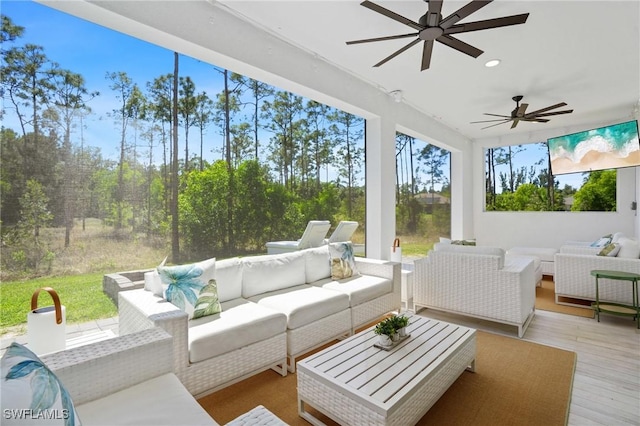 sunroom / solarium featuring a ceiling fan