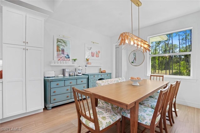 dining space featuring baseboards and light wood-style floors