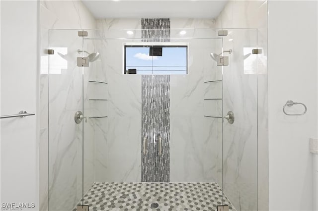 bathroom featuring a marble finish shower