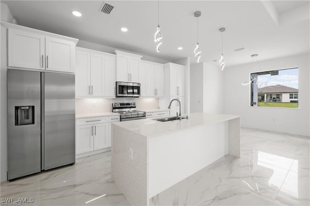 kitchen featuring recessed lighting, stainless steel appliances, marble finish floor, white cabinetry, and a sink