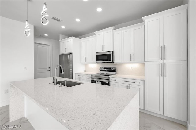 kitchen featuring a center island with sink, marble finish floor, appliances with stainless steel finishes, and a sink