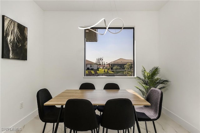 dining area with baseboards and a notable chandelier