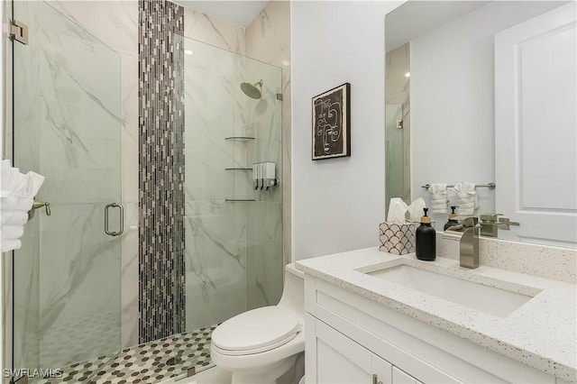 full bath featuring vanity, toilet, and a marble finish shower