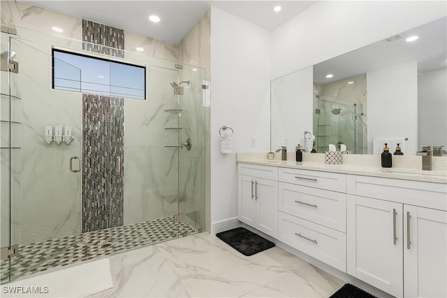 full bath featuring a marble finish shower, double vanity, recessed lighting, a sink, and marble finish floor