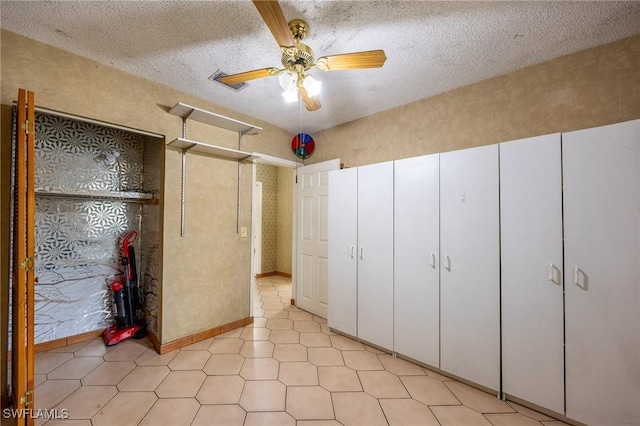 unfurnished bedroom featuring visible vents, ceiling fan, and a textured ceiling