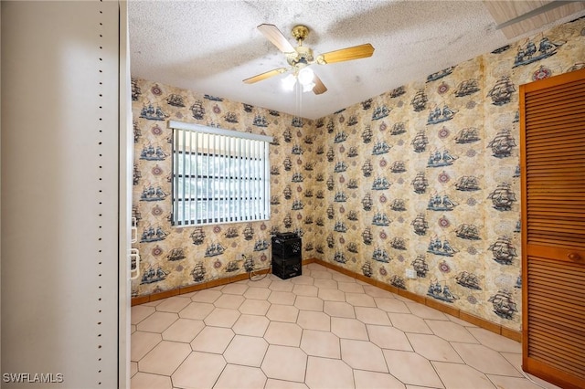 empty room featuring a textured ceiling, ceiling fan, and wallpapered walls