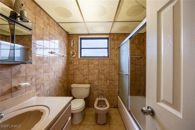 bathroom with enclosed tub / shower combo, tile patterned flooring, toilet, vanity, and tile walls