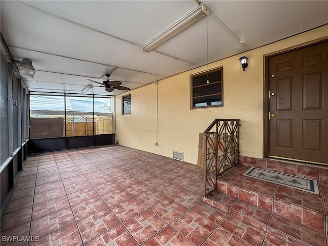 unfurnished sunroom featuring a ceiling fan