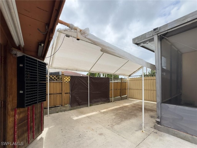 view of patio featuring fence and a detached carport