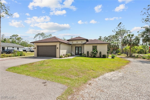 view of front of property with stucco siding, a front lawn, french doors, a garage, and aphalt driveway